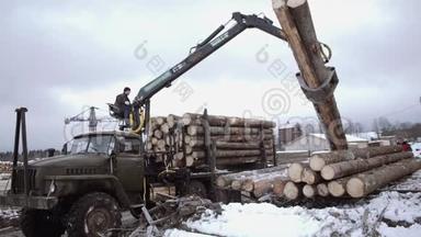 起<strong>重机</strong>械装载机在锯木厂从重型卡车上卸下木材