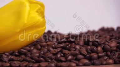 咖啡豆上有白色的杯子和黄色的花。 咖啡豆里的白色小杯子。 咖啡豆上的黄色郁金香。