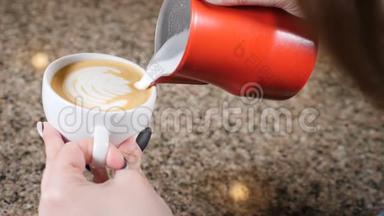 咖啡店。 咖啡师准备咖啡。 准备拿铁。 咖啡师把热牛奶倒入一杯浓咖啡中。 拿铁艺术