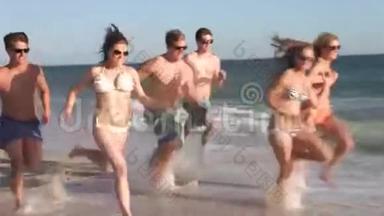 一群青少年沿着海滩奔跑