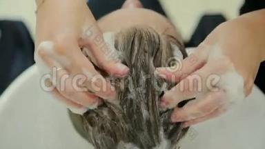 女理发师手握手指间锁毛，梳子和剪刀特写.. 用剪刀修剪头发的尖端。 圣斯特
