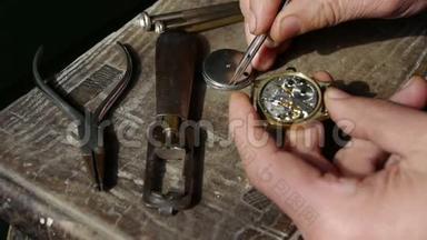 在木桌上安装手表，很多工具。