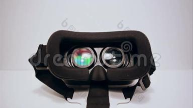 虚拟现实眼镜为智能手机的白色背景，智能手机正在工作，男人的手拿着它们，戴上它们