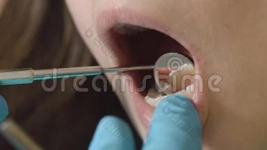 口腔和牙齿的检查。 在口腔检查过程中，病人年轻女孩张开嘴的特写。