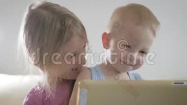 可爱的弟弟<strong>妹妹</strong>使用数字平板电脑，微笑着，看上去很开心。 兄弟姐<strong>妹</strong>玩得开心