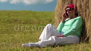 老太太坐在草堆旁用手机<strong>交流</strong>