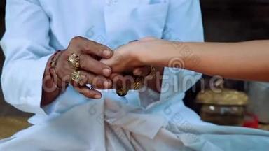 巴厘岛牧师牵着女人的手做手掌阅读