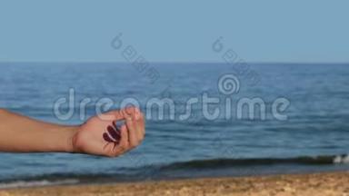 双手放在沙滩上，手持全息图像文字