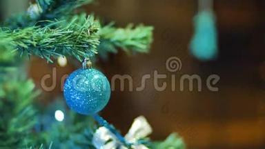 女人的手在圣诞树上挂球。 寒假圣诞节和新年装饰。 闪烁的加兰