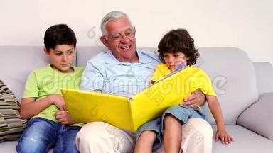 老人坐在沙发上和孙子们一起看相册