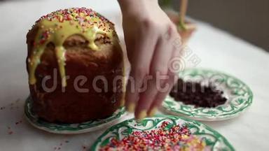 复活节蛋糕上有黄色的糖霜和五颜六色的<strong>花洒</strong>在白色的桌子上。 女孩甜蜜的谷物洒复活节蛋糕