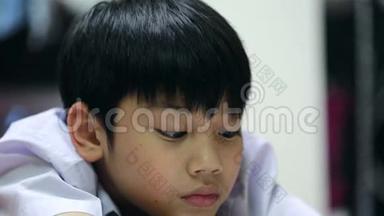亚洲可爱男孩在家里地板上看书