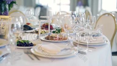 在餐厅的白色桌子上摆放健康食品和白色盘子和用具