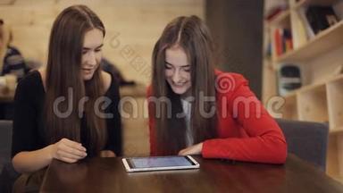 两个快乐的女友在咖啡馆里微笑着