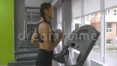 年轻强壮的女人，有着完美的健身身材，穿着运动服，在健身房跑步机上跑步。 女子有氧运动