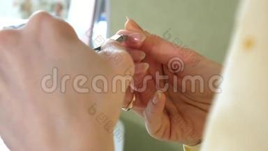 女人在家里给自己做指甲。