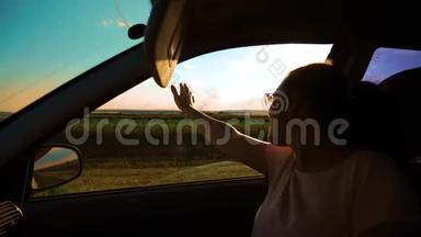 女孩挥手在窗户阳光下，风在<strong>汽车</strong>慢动作<strong>视频</strong>。 年轻快乐的女孩开<strong>汽车</strong>