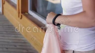 在夏日，女人的双手将长而淡粉色的纺织品撕下接缝