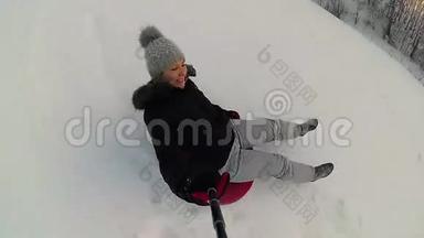 快乐的女孩骑着雪管在雪道上微笑。慢动作。 <strong>冬天</strong>的雪景。 <strong>户外运动</strong>