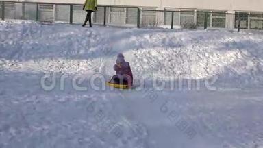 儿童骑在山上的盘子里，儿童在冬天雪橇