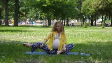 美丽的孕妇在户外做产前瑜伽。 怀<strong>孕期</strong>间的运动、健身和健康生活方式