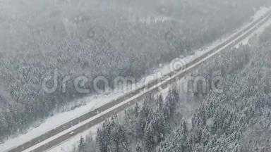 道路在冬季森林与驾驶汽车在降雪。 空中全景。 消失的角度
