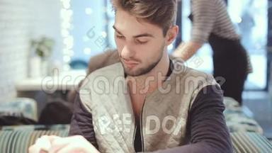 有智能手机的年轻人坐在咖啡馆里，特写