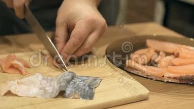 厨师切三文鱼，切三文鱼，刀切鱼，三文鱼，厨师站在寿司吧的厨房里