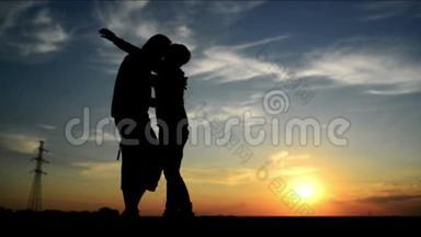 在夕阳下的约会，拥抱和亲吻。 浪漫的爱情场景，