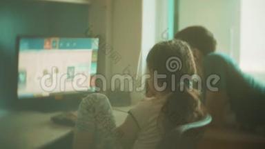 孩子们在电子游戏中玩电脑。 男孩和女孩玩在线电子游戏慢动作视频。 孩子们玩游戏