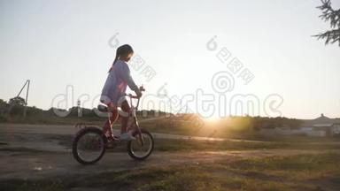 骑自行车的<strong>孩子</strong>在日落时骑自行车享受自由。 日落时骑自行车在<strong>乡下</strong>的女孩。