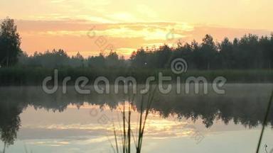 <strong>清晨</strong>在湖边。 雾在水面和橙色的<strong>天空</strong>在日出之前。 这个湖被森林包围着。 移动