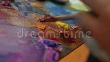 艺术家在调色板上混合油漆，艺术在调色板上刷混合油漆，艺术家在调色板上刷混合彩色油画。