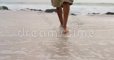 在阳光明媚的4k天气里，<strong>一个人</strong>赤脚在海滩上行<strong>走</strong>
