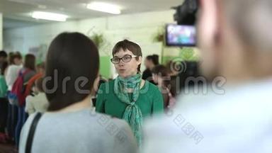 戴眼镜的女人在镜头前接受采访