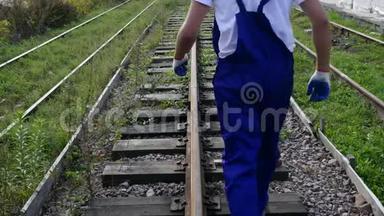 铁路工人戴着白盔沿着铁路行走