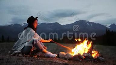 年轻的女孩和男人喝茶咖啡，休息篝火背景。