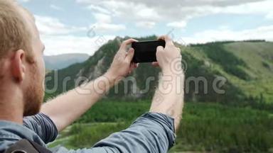 男人用智能手机拍照，山景