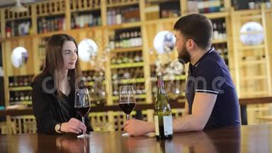 一个女孩和一个餐馆里的男人交流并喝红酒，一对年轻夫妇在一张桌子上喝红酒。