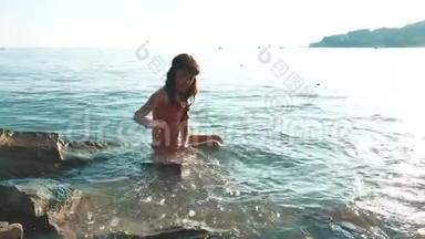 <strong>小女孩</strong>用石头和石头在海里<strong>洗澡</strong>。 少女女儿在水中游泳，生活方式在海浪中