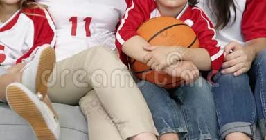 带着微笑的家人和奶奶一起看篮球赛