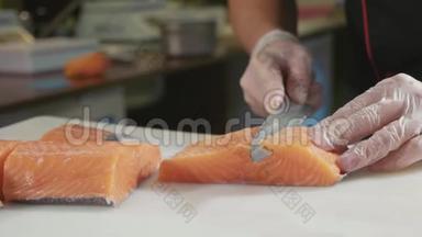 在<strong>寿司</strong>吧里，在手套里为<strong>寿司厨师</strong>切鲜鲑鱼。
