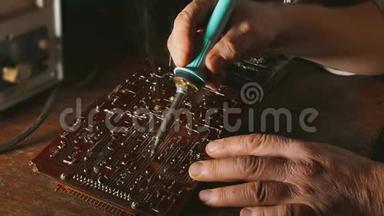 老人修理芯片无线电技师烟来修理烙铁。 工程师或技师修理