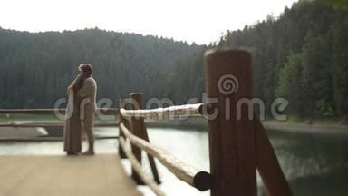 美丽的夫妻相爱，穿着传统的乌克兰服装，轻轻地拥抱在山湖码头上。 呼吸