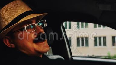 戴着胡子戴着<strong>帽子</strong>的人，戴着眼镜坐在车里唱歌。 <strong>夏日</strong>。 乐趣