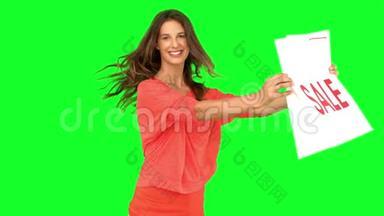 女人一边旋转一边在绿色屏幕上展示购物袋