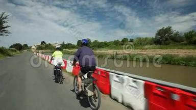 慢动作-退休夫妇在河边骑自行车度假