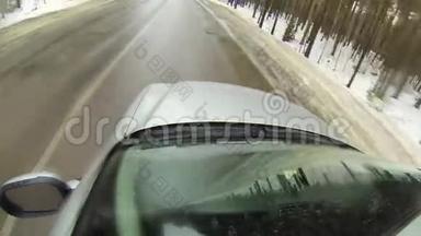 在森林的冬季道路上行驶时，摄像机安装在汽车上。 它会变成雪。