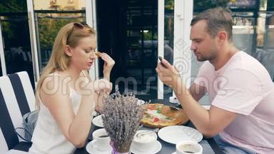 一对在户外咖啡馆。 男女<strong>约会</strong>。 一个搭档看着他的<strong>手机</strong>，第二个试图和他说话。 4k