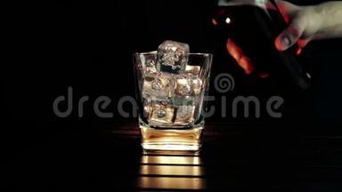 酒吧老板把威士忌倒在杯子里，木桌上放<strong>冰块</strong>，黑黑的背景，重点放在<strong>冰块</strong>上，威士忌放松时间